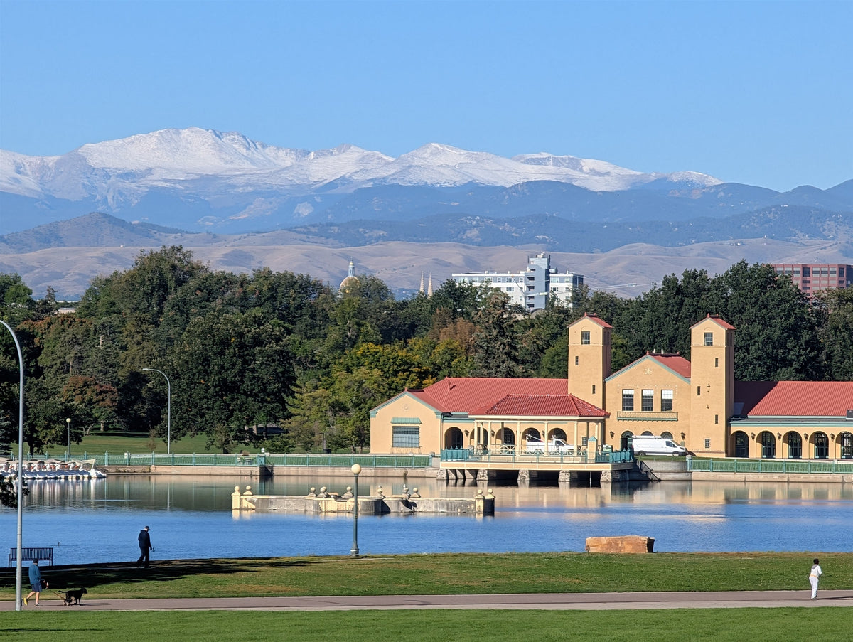 downtown denver and the snowy rockies behind the city park boathouse